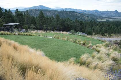 El imponente paisaje prestado, la cordillera y la plantación de pinos ponderosa en El Desafío, San Martín de los Andes. El jardín se va desdibujando hacia la estepa y allí se plantaron especies arbóreas nativas.