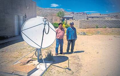 El impulsor: Rufino Llampa (izquierda); comisionado de Mina Pirquitas (Jujuy), y un colaborador junto a una antena satelital; Llampa promovió la llegada de Internet para quebrar el aislamiento