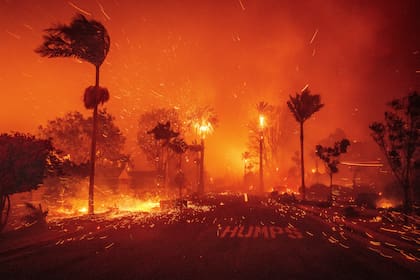 El incendio de Palisades arde en un vecindario en medio de fuertes vientos en el barrio de Pacific Palisades en Los Ángeles, el martes 7 de enero de 2025. (AP Foto/Ethan Swope)