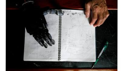 El ingeniero Chang Hsien-Liang, de 46 años, quien construyó su propio brazo utilizando la tecnología de impresión 3D, examina sus notas que muestran la condición de Angel Peng, de ocho años, que perdió la mano en Tainan,Taiwan