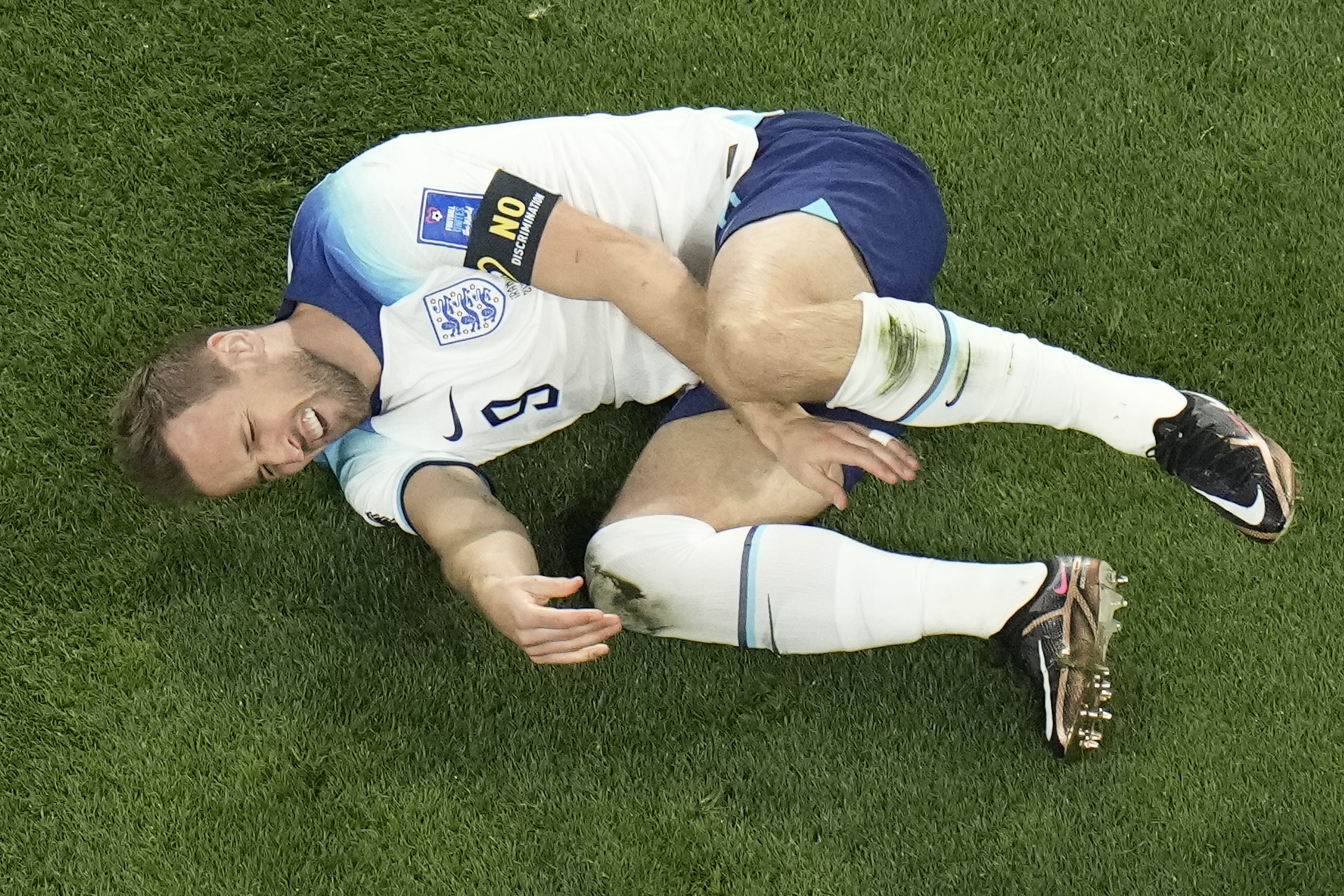 El inglés Harry Kane hace un gesto de dolor tras recibir un golpe del iraní Morteza Pouraliganji en un juego del Grupo B del Mundial que enfrentó a ambos equipos, en el estadio Jalifa Internacional, en Doha, Qatar, el 21 de noviembre
