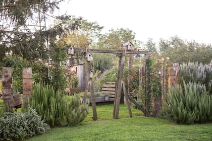 El ingreso a la huerta entre rosas, romeros, aromáticas y clematis