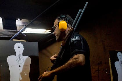 El instructor brasileño de tiro Jorge Alberto de Moura revisa el objetivo en el Calibre 12