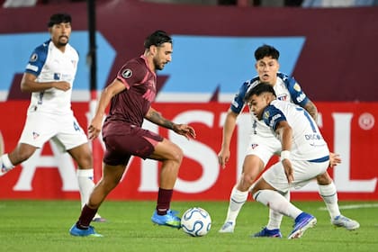 El intento de Eduardo Salvio, de Lanús, frente a la complicada marca de Liga Deportiva Universitaria