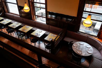 El interior propone un salón de doble altura, pisos de madera y boiserie perimetral