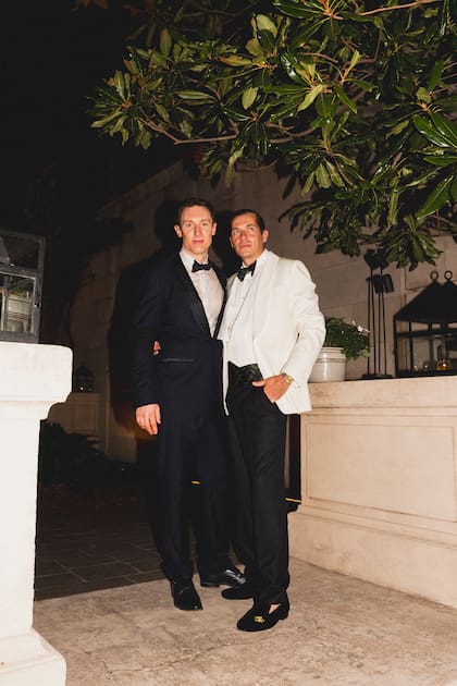 El interiorista James Boyd Niven, de smoking blanco, junto a Ross Parker