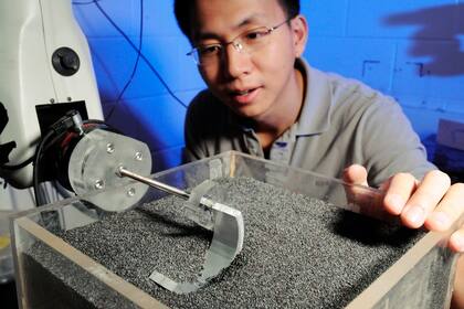 El investigador Chen Li analizando el comportamiento del diseño de la pata para moverse en la arena