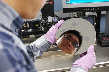 El investigador Hongsik Park de IBM examina una placa de chips desarrollada con nanotubos de carbono