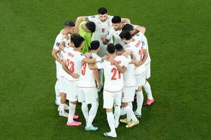 El iraní Mehdi Taremi, en el centro a la derecha, habla con sus compañeros en el campo antes del comienzo del partido de fútbol del grupo B de la Copa del Mundo entre Irán y Estados Unidos en el estadio Al Thumama en Doha, Qatar, el martes 29 de noviembre de 2022. (AP Photo/Hassan Ammar)