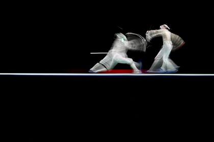 El italiano Luigi Samele (izq.) Compite contra el chino Xu Yingming en la pelea de clasificación individual de sable masculino durante los Juegos Olímpicos de Tokio 2020 en el Makuhari Messe Hall en la ciudad de Chiba, prefectura de Chiba, Japón, el 24 de julio de 2021.