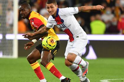 El italiano Marco Verratti, de PSG, intenta llevarse la pelota ante la marca de un rival de Lens. Los campeones de Francia perdieron en el debut por 1 a 0.