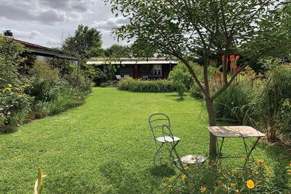 El jardín de Heather y, al fondo, el vagón de tren transformado en simpático lugar para recibir huéspedes.