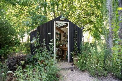 El jardín de la paisajista y jardinera Daiana Quintana en la localidad de San Vicente tiene su propio invernadero que antes era la casita de juegos y se revistió de madera, bajo la sombra de un roble, álamos y un azota caballos.