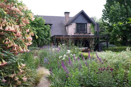 El jardín se sectorizó para cubrir las expectativas de toda la familia. En primer plano, un sector al sol con un gran cantero con rosas, salvias, iris, verbenas, gramíneas y muchas anuales que se van resembrando entre la superficie de granza.