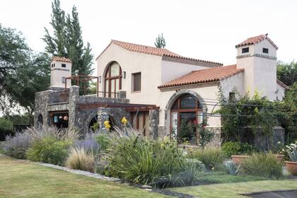 El jardín trasero, desde donde se pueden ver los diferentes sectores. Los Sporobolus maximus, gramíneas nativas en todo su esplendor, separan la galería del living. Cerca de unos grandes algarrobos existentes, en la zona más soleada, se proyectó la huerta.