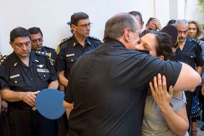 El jefe de la Policía Federal, comisario general Román Di Santo, abraza a Fernanda Taus, esposa del agente Miguel Verón, asesinado en marzo de 2014 cuando intentó detener a dos ladrones en Flores