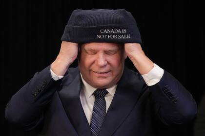 El jefe del gobierno de Ontario, Doug Ford, se pone una gorra tras una rueda de prensa con el jefe Sonny Gagnon de la Primera Nación Aroland en Queens Park, la legislatura provincial, en Toronto, el martes 28 de enero de 2025. (Chris Young/The Canadian Press via AP)