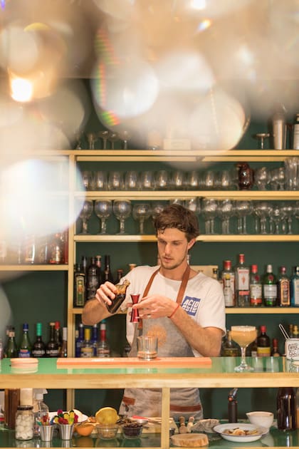 El joven bar tender Sebastián Falco Rosas hace magia y coctelería en la barra de Flores y Besos.