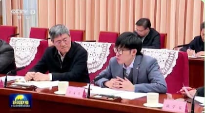 El joven creador de DeepSeek, Liang Wenfeng (derecha), durante una reunión con funcionarios del gobierno chino