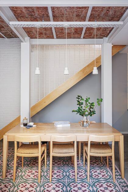 El juego de mesa y sillas, de lenga (Navarro Hábitat), está iluminado por tres lámparas colgantes de cemento (Estudio Chalé).