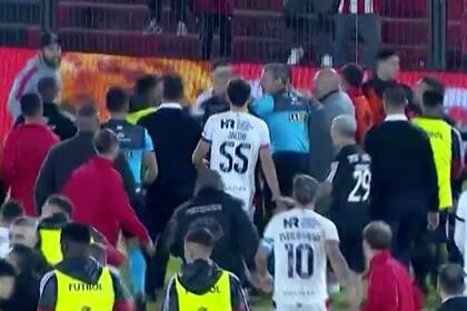 El juez Ariel Penel y sus asistentes intentan mediar en un final de partido inesperado entre Newell´s y Deportivo Riestra, cuyos jugadores y ayudantes de los cuerpos técnicos quedaron involucrados en una gresca.