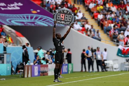 El juez asistente muestra el tiempo agregado durante el encuentro entre Gales e Iran en el Mundial de fútbol de Qatar