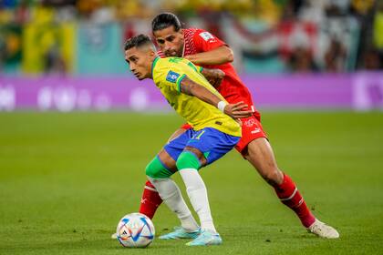 El jugador brasileño Raphinha cuida la pelota ante la presión de Ricardo Rodriguez durante el partido entre Brasil y Suiza
