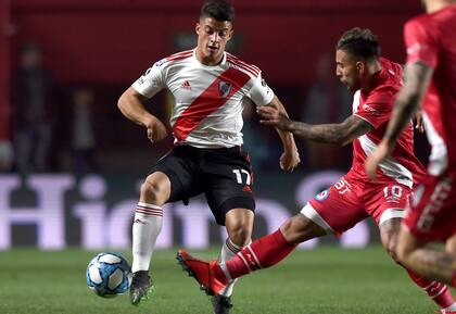El juvenil Elías López maniobra con la pelota ante la marca de Damián Batallini