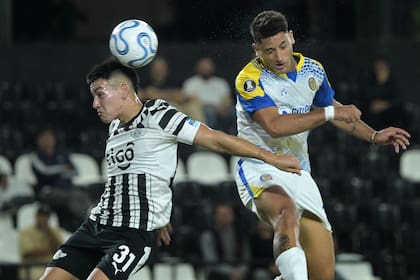 El juvenil Thiago Fernández en el duelo aéreo con Alejo Véliz: el delantero de Rosario Central salió disgustado ante el cambio, perola victoria le devolvió la sonrisa