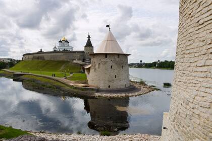 El kremlin de Pskov, recinto amurallado que protegía la ciudadela. El edificio blanco dentro de la fortaleza es la catedral de la Santísima Trinidad.