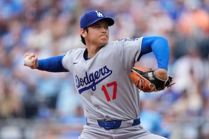 El lanzador abridor de los Dodgers de Los Ángeles, Shohei Ohtani, lanza durante la primera entrada de un partido de béisbol contra los Reales de Kansas City, el sábado 28 de junio de 2025, en Kansas City, Misuri. (AP Photo/Charlie Riedel)