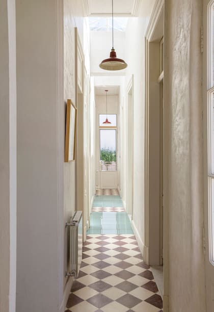 El largo y alto pasillo que lleva a los dormitorios y, al fondo, la terraza, con mosaicos calcáreos hechos a pedido.