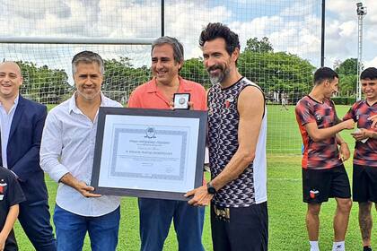 El legislador Busatto (a la izquierda) en el momento de la entrega del reconocimiento.