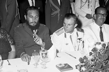 El líder cubano Fidel Castro, a la izquierda, fumador habitual de puros, abre una caja de cigarrillos rusos mientras está sentado junto al astronauta ruso Yuri Gagarin en una recepción durante la celebración de cuatro días en la Embajada de Rusia. en la Habana el 26 de julio de 1961