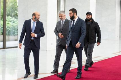 El líder de facto de Siria, Ahmad al-Sharaa, al frente, conocido anteriormente como Abu Mohammed al-Golani, camina en el palacio presidencial antes de reunirse con Walid Ellafi, ministro libio de comunicación y asuntos políticos, en Damasco, el sábado 28 de diciembre de 2024.