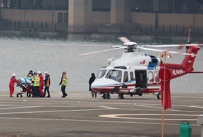 El líder del partido de la oposición surcoreana, Lee Jae-myung, quien fue atacado en Busan, desciende de un helicóptero en una camilla para ser trasladado al Hospital de la Universidad Nacional de Seúl, en un helipuerto en Seúl el 2 de enero de 2024.