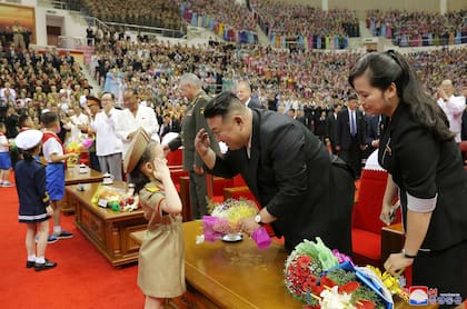 El líder norcoreano Kim Jong Un recibiendo un ramo de flores de unos niños en la gran actuación de celebración del 70 aniversario de la victoria de la Guerra de Liberación de la Patria en el Gimnasio Ryugyong Chung Ju-yung de Pyongyang.