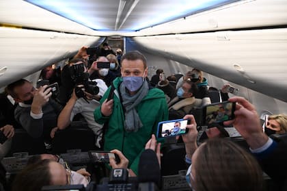 El líder opositor ruso Alexei Navalny camina para tomar su asiento en un avión de la aerolínea Pobeda con destino a Moscú antes del despegue desde el Aeropuerto de Berlín Brandeburgo (BER) en Schoenefeld, al sureste de Berlín, el 17 de enero de 2021. 