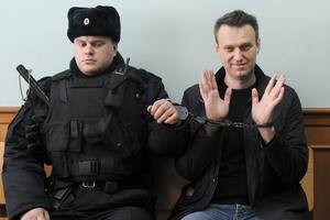 El líder opositor ruso Alexei Navalny (derecha) posa para la prensa mientras está esposado en un tribunal en Moscú, Rusia, el jueves 30 de marzo de 2017. (AP Foto, Archivo)