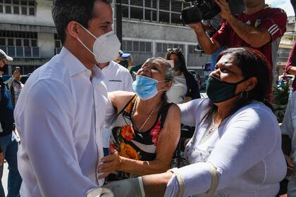 El líder opositor venezolano Juan Guaidó saluda a sus seguidores a su llegada para ofrecer una conferencia de prensa durante el día de la "consulta popular" en la Plaza Bolívar en Chacao, este de Caracas, el 12 de diciembre de 2020