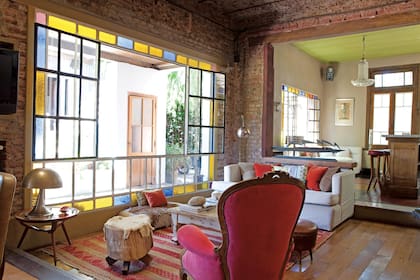 El living en desnivel tiene piso de pino tea heredada, alfombra (Casa Fez, Uruguay), sillón tapizado en pana (Compañía del Comercio) y sofá hecho a medida.