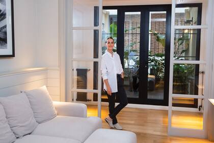 El living íntimo tiene vista a un balcón repleto de plantas, un pequeño oasis verde en medio de la ciudad.