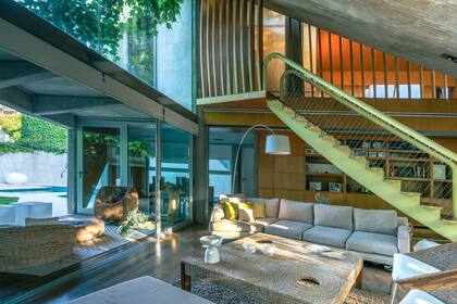 El living, la escalera que la atraviesa y las puertas vidriadas que conectan exterior e interior