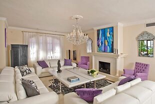 El living principal de la casa con chimenea en absoluto blanco en combinación con violeta