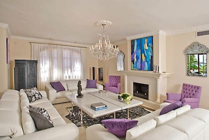 El living principal de la casa con chimenea en absoluto blanco en combinación con violeta