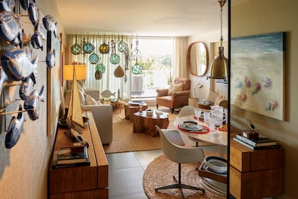 El living tiene un ventanal con vista a la avenida Roosevelt. Las boyas de diferentes tamaños y colores que cuelgan del techo llaman la atención. Para generar más amplitud en este departamento de 100 metros cuadrados, Dotto decidió agregar varios espejos.