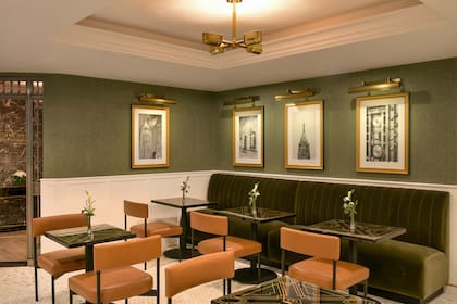 El lobby tiene sillones verdes y un ambiente acogedor y sofisticado que fusiona elegancia y comodidad en un espacio emblemático del edificio