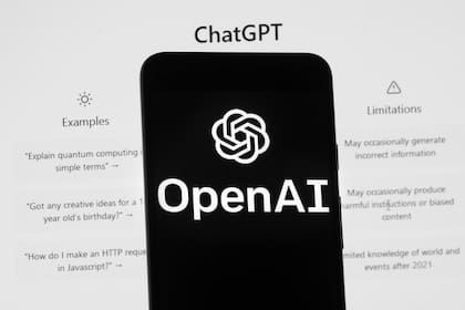 El logo de OpenAI es visto en un celular frente a la pantalla de una computadora que muestra la pantalla inicial de ChatGPT, el 17 de marzo de 2023, en Boston