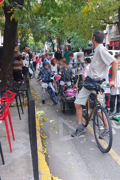 El maestro Adrián Sánchez marcha adelante de los niños de la escuela N°11 de Caballito, que van a la escuela en bicicletas, monopatines, patinetas y patines, todos medios de transporte sustentables