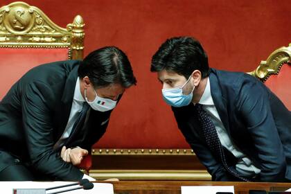 El mandatario italiano Giuseppe Conte conversa con su ministro de salud, Roberto Speranza; Italia sufrió un duro golpe en su economía, pero celebró que los datos mostraron que a alguno de sus socios europeos les fue peor